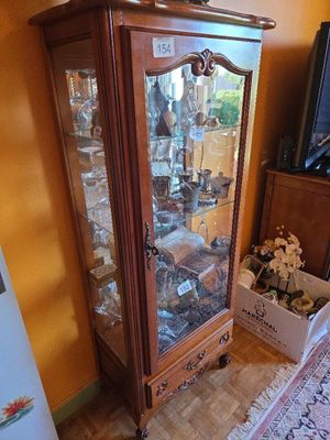 a wooden cabinet with a glass door in a living room