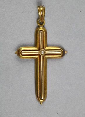 gros plan d'une croix en or sur une surface blanche