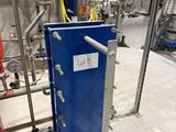 a blue panel with a sign on it in a room with pipes and valves