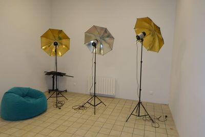 trois parapluies dans un coin de la pièce, près d'un pouf bleu
