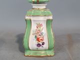 un petit pot vert et blanc orné de fleurs
