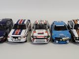 five different model cars are lined up in a row on a white surface