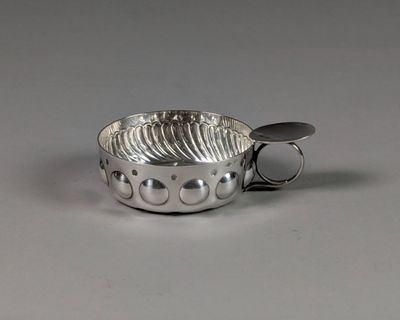 un bol en argent avec une cuillère sur une table
