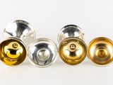 three silver, gold and silver knobs on a white background