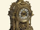 une horloge en or posée sur une surface blanche