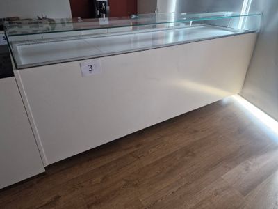 a glass display case in the middle of a wooden floor
