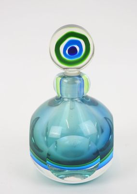une bouteille en verre bleue surmontée d'un œil vert