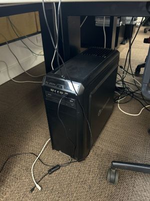 un ordinateur posé par terre sous un bureau