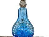 a blue glass bottle sitting on top of a table