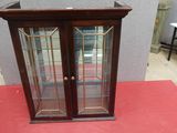 une vitrine aux portes vitrées posée sur un tapis rouge