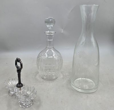 trois vases en verre et une bouteille posés sur une table