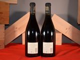 two bottles of wine sitting next to each other on a table