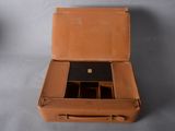 a brown suitcase that is open on the floor