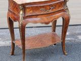 a small wooden table with a marble top on it
