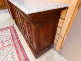 a wooden cabinet with a marble top in a room