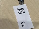 une cuillère en argent sur laquelle est accrochée une étiquette, posée sur une table