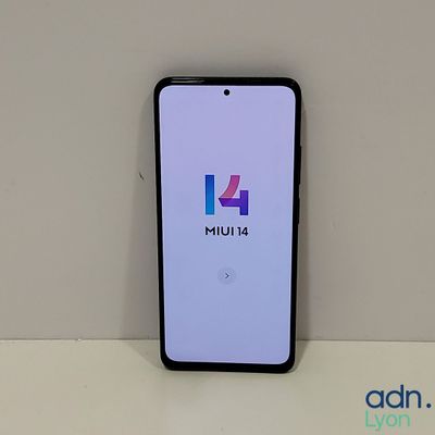 a close up of a phone on a table with a logo on the screen