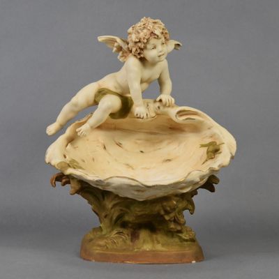 une image représentant la statue d'un garçon assis sur un coquillage