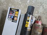 a can of water and a canister of gas next to a box