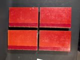 three pieces of red and orange soap sitting on top of a black counter