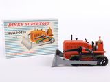 a toy bulldozer and a boxed box on a white surface