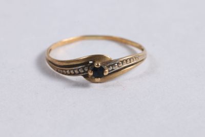 gros plan d'une bague en or avec une pierre noire