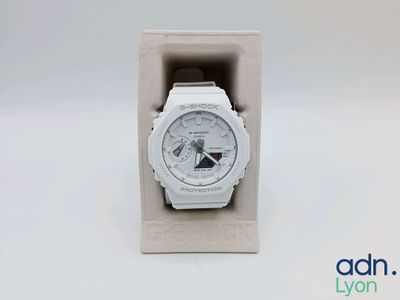 a close up of a watch in a box on a white surface