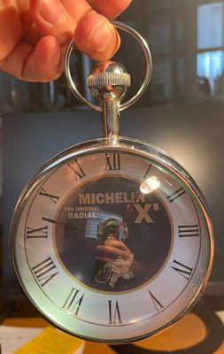 Quelqu'un tient une montre de poche sur laquelle figure la photo d'un homme.