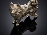 statue en argent représentant un chien sur un fond noir