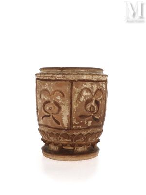 a brown cup that is sitting on a white surface