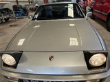 a silver car parked in a garage with other cars in the background