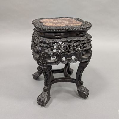 an ornately carved table with a marble top on a stand