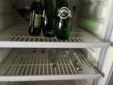 two bottles of beer and a glass in a refrigerator