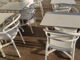 many tables and chairs that are outside on the patio