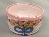 a small bowl with a bow and flowers painted on it
