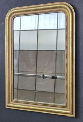 une image d'un miroir encadré d'or accroché à un mur