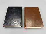 deux livres, l'un marron et l'autre noir, posés côte à côte sur une surface blanche
