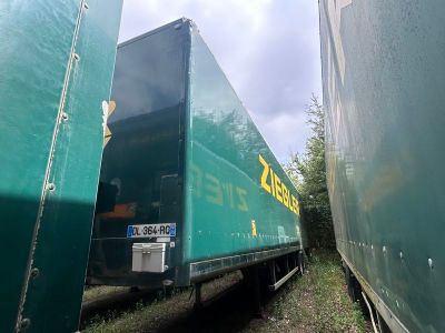 deux semi-remorques verts garés l'un à côté de l'autre