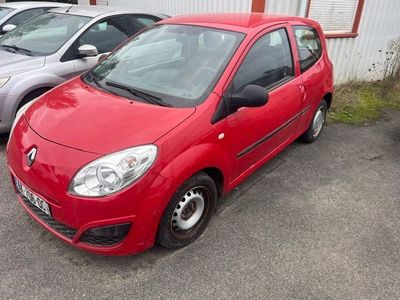 une voiture rouge garée dans un parking à côté d'autres voitures