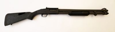 un fusil noir posé sur une table blanche, sur fond blanc
