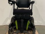 une trottinette électrique posée sur une palette devant un mur blanc