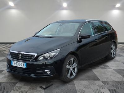 la voiture noire est garée sur un sol en damier dans le garage
