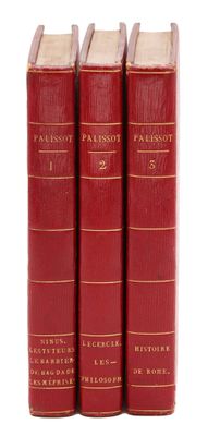 trois livres rouges superposés sur une surface blanche