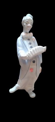 une figurine représentant une femme en robe blanche