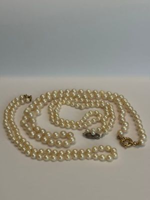 gros plan d'un collier de perles sur une surface blanche