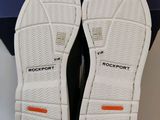 the soles of a pair of white shoes are in a blue box