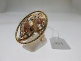 gros plan d'une bague sur une surface blanche avec une étiquette de prix