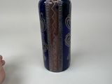 a hand holding a blue and white vase next to a hand