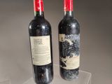 two bottles of wine sitting on top of a table