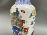 a blue and white vase with a bird and flowers on it